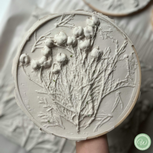 Relieve de yeso con motivo floral en formato circular, no incluye marco.